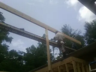 Carpenter setting a ridge beam over a new addition frame — Ice Dam Removal by Roofing Brothers in Eupora
