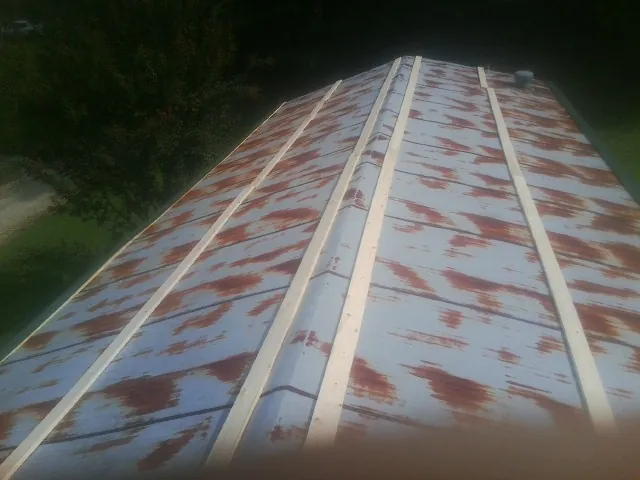 Rusted metal roof panels with new wood purlins before replacement — Storm Damage Roof Repair in Eupora by Roofing Brothers