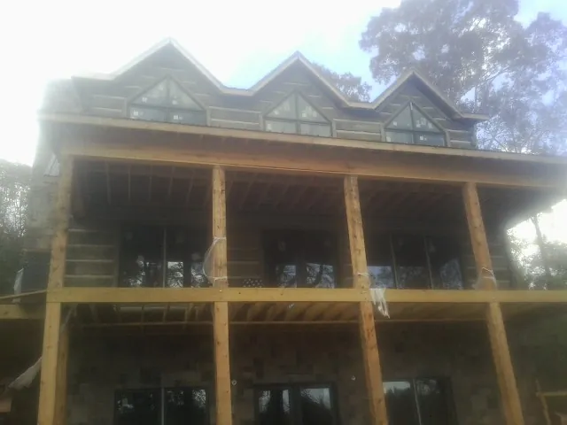Dormers and porch framing on a large log home under construction — Roof Coating work by our crew in Eupora